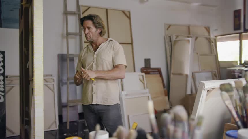 An artist begins to paint on a canvas