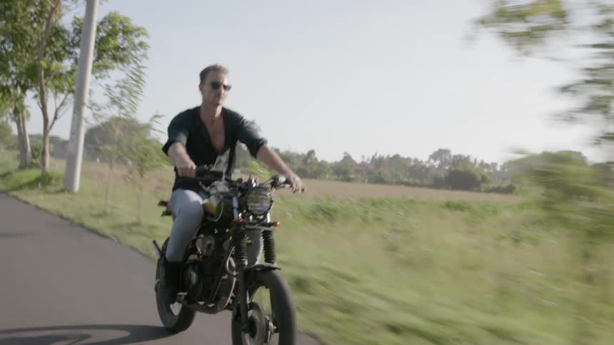 A motorcyclist rides in a countryside