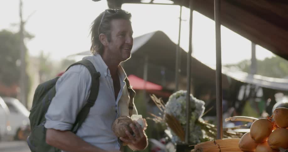 Man shops at a farmer's market and gives a thumbs up