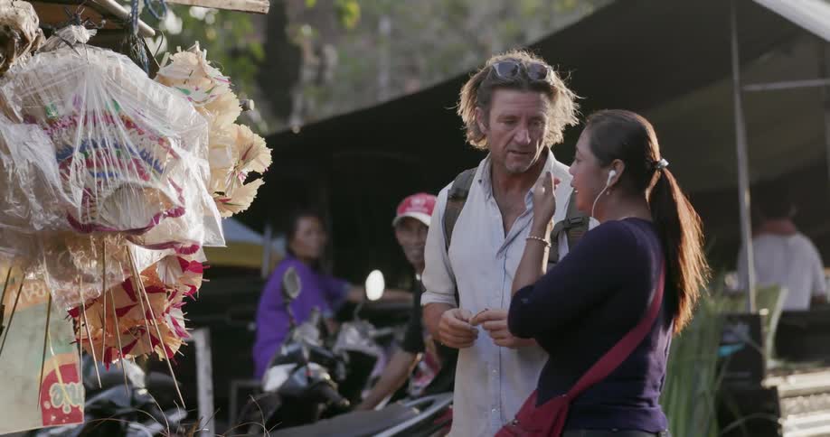 Man and woman talk and point in a market