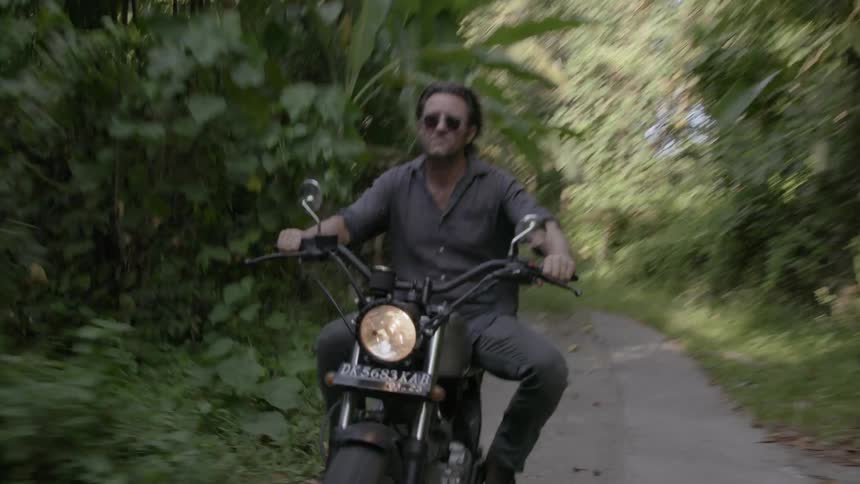 Man motorcycles in a jungle