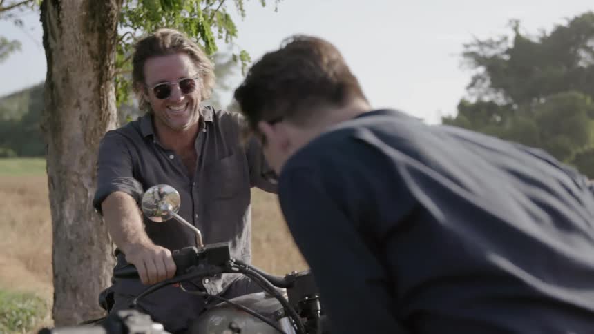 Men sit on motorcycles talking
