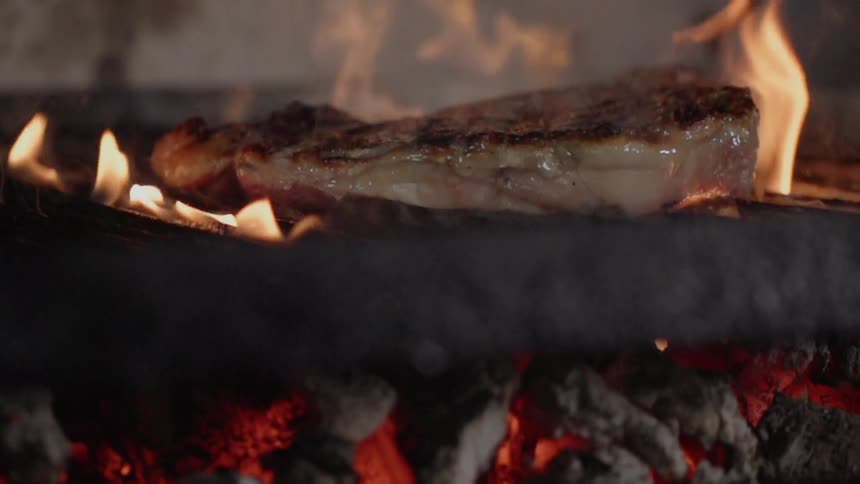 Steaks are cooked on a grill