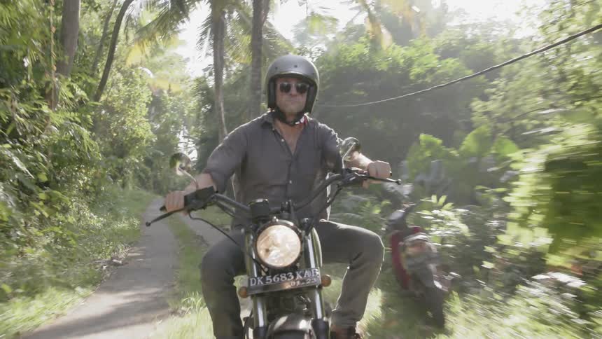Man motorcycles in a jungle