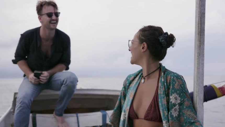 A man and woman ride on a boat together