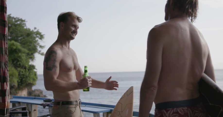 Two men talk by the water