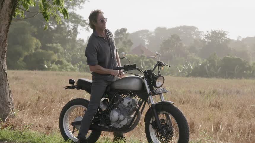 A man motorcycles in the countryside