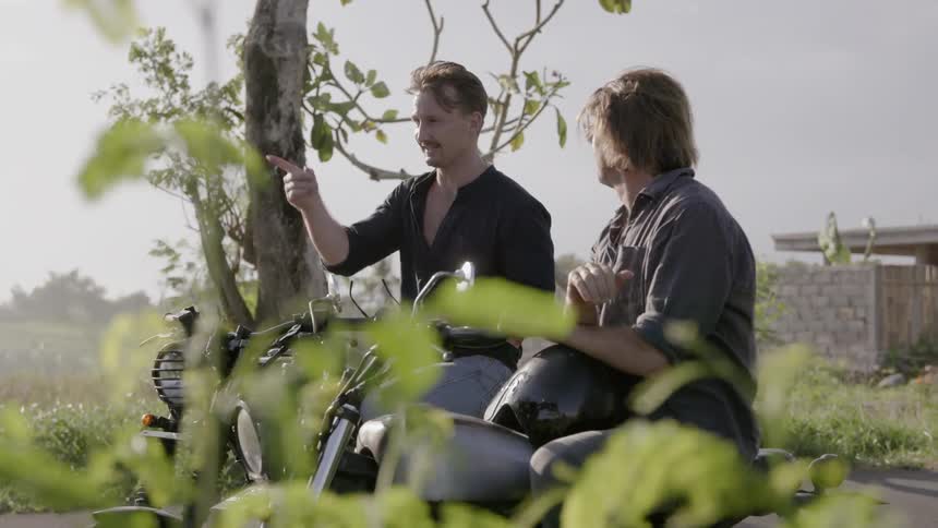 Men sit on motorcycles talking