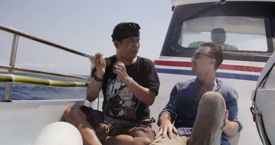 Men talk while riding in a boat
