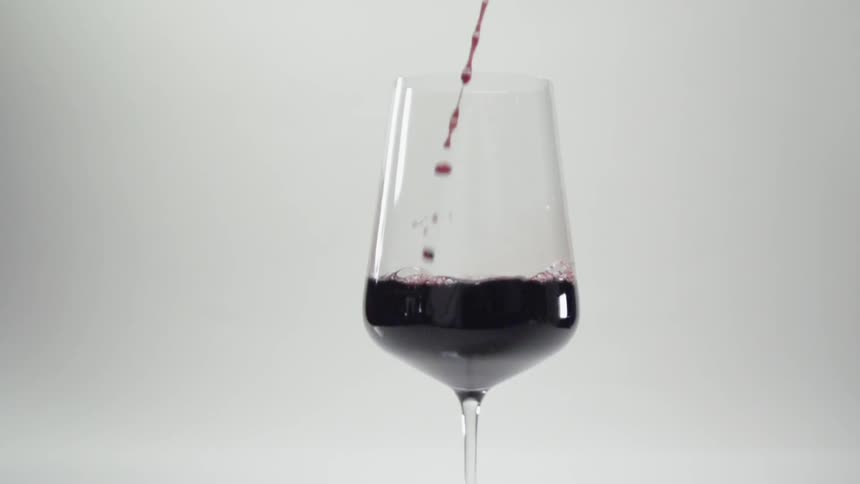 Red wine is poured into a glass