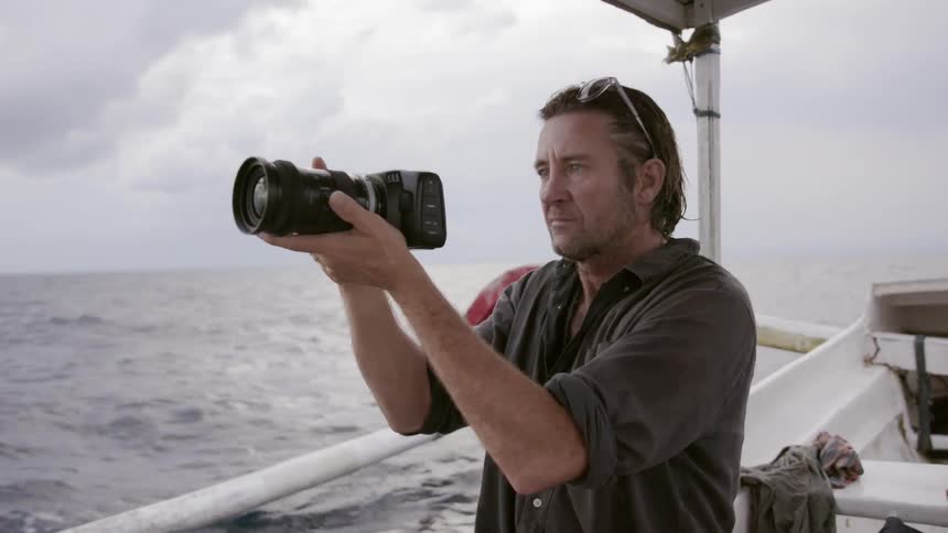 Man in a boat takes a photo with a camera