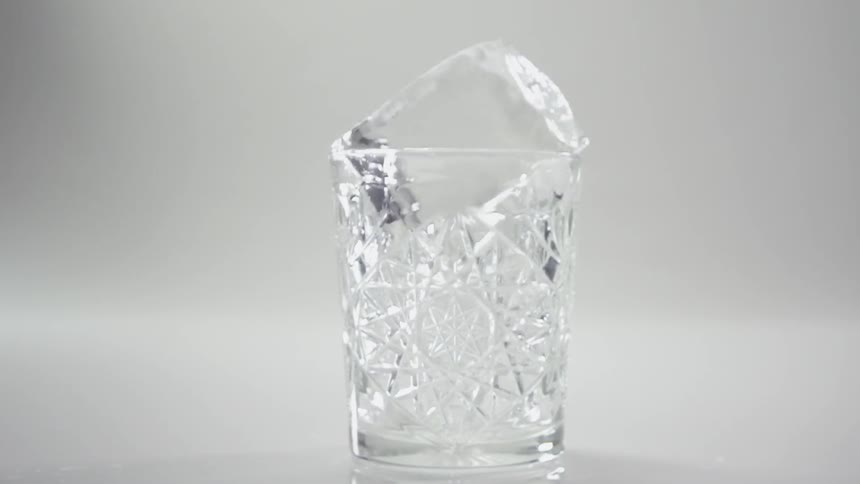 An ice cube falls into a glass