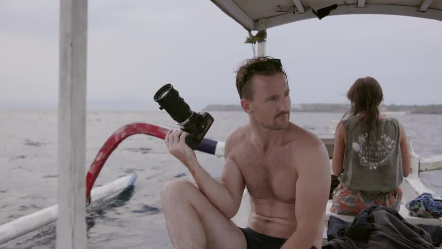 A man photographs from a moving boat