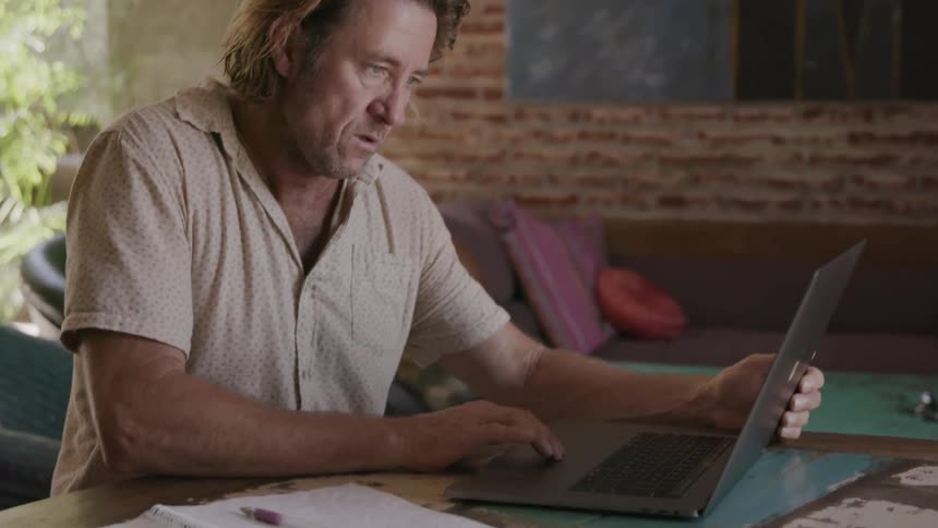 Man types on a laptop