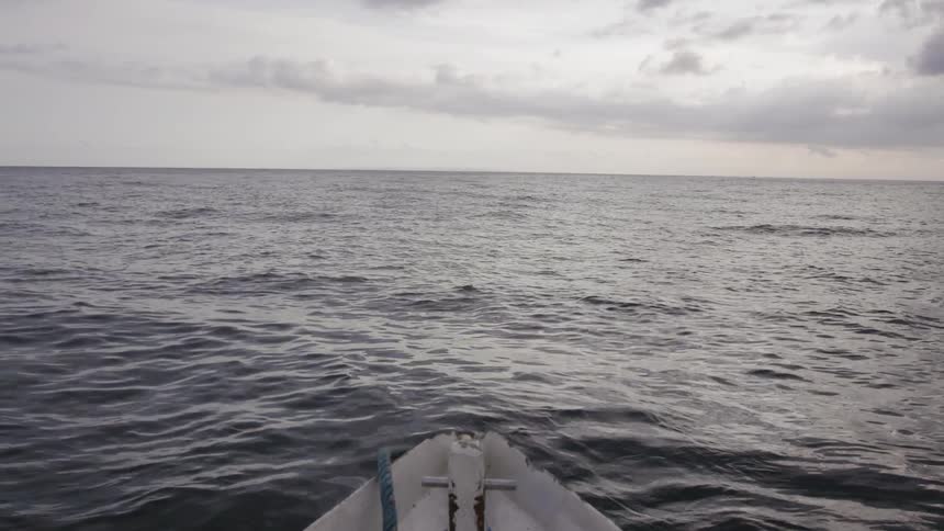 Legs and feet stretched out in a small boat on the ocean