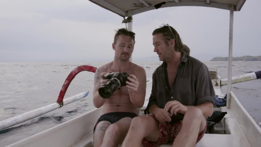 Two men talk together while riding on the boat