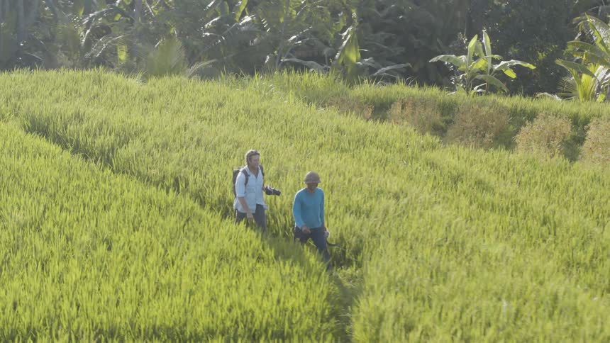 Two men walk across a grassy field