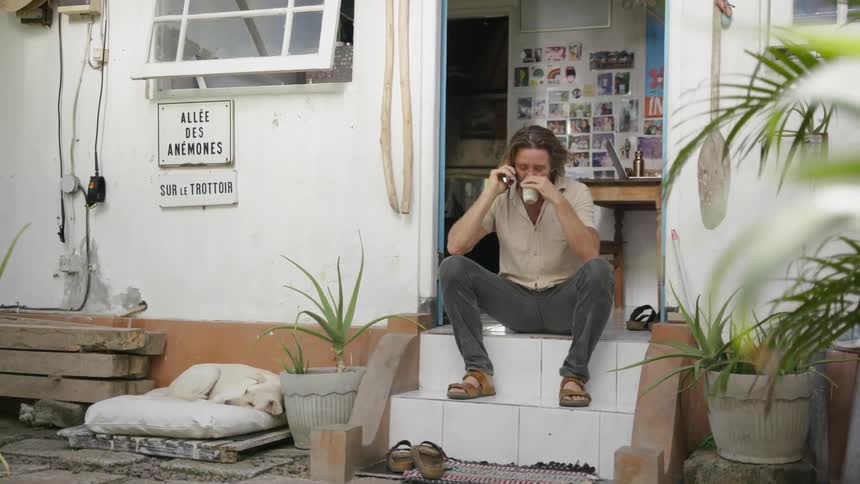 Man talks on the phone on front doorsteps