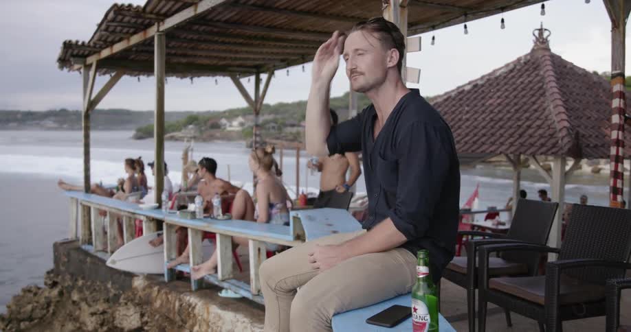 A man sits on the ledge overlooking the water
