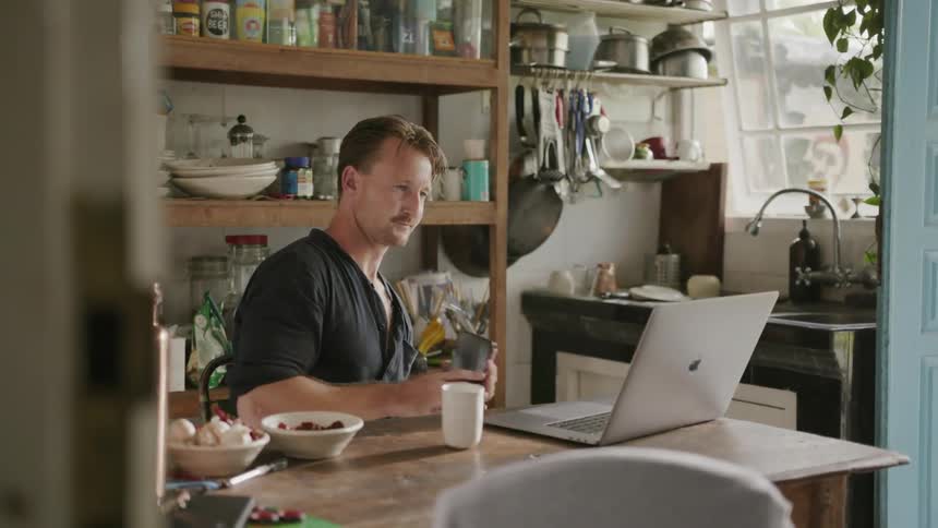 A man uses his laptop in a kitchen