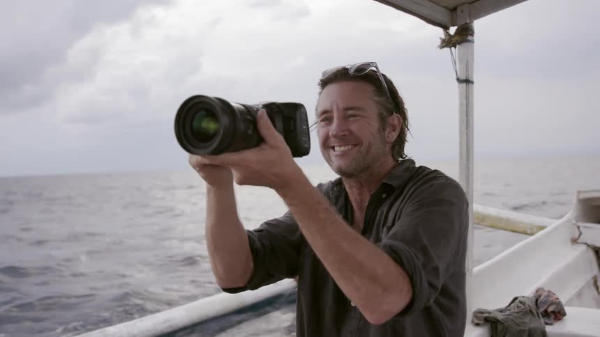 Man takes a photograph on a boat