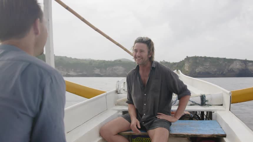 Two men talk while sailing on the small boat