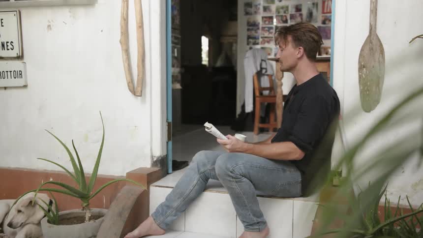 Man sits on a porch reading a book