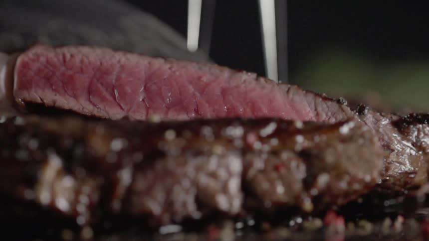 A knife cuts a steak