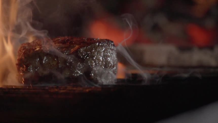 A steak is cooked on a grill