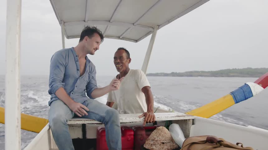 Two men talk while riding in a boat