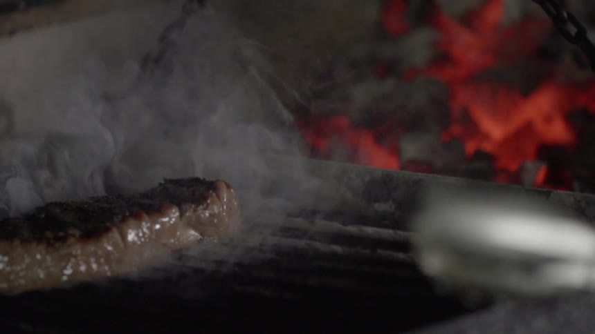 A steak is cooked on a grill