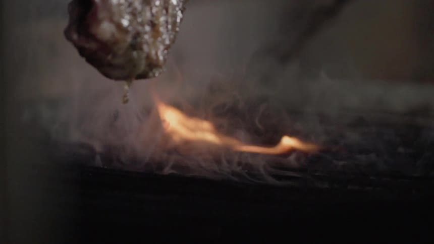 Prime rib is flipped on a cooking grill