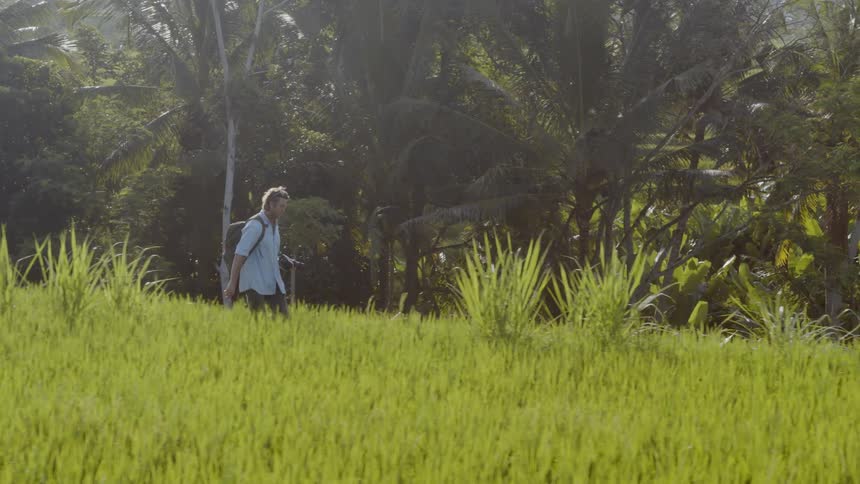 Man hikes across a grassy field
