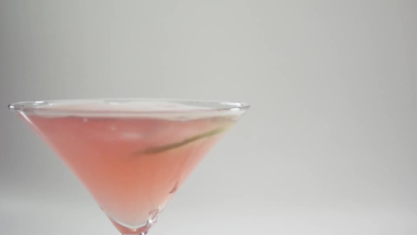 A lime slice falls into a cocktail