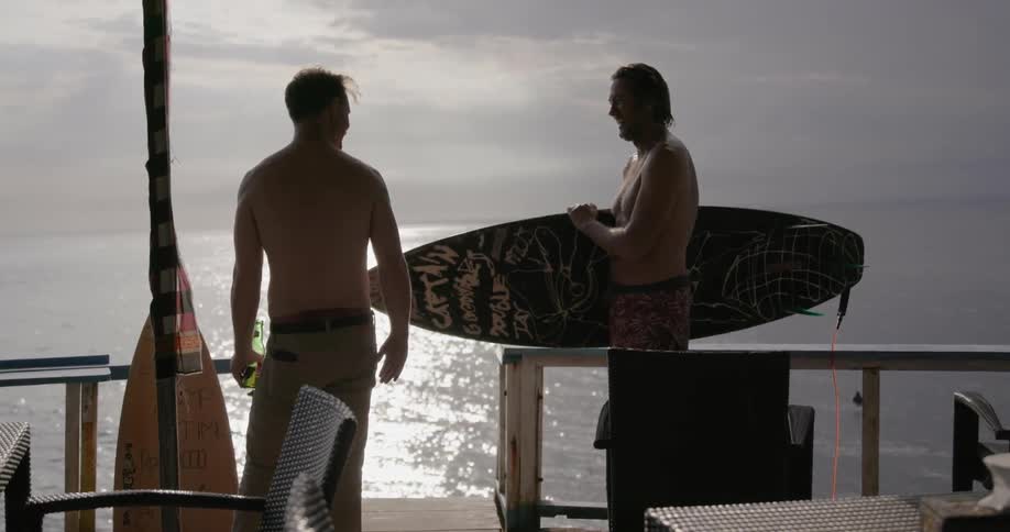Two men talk to each other on a pier