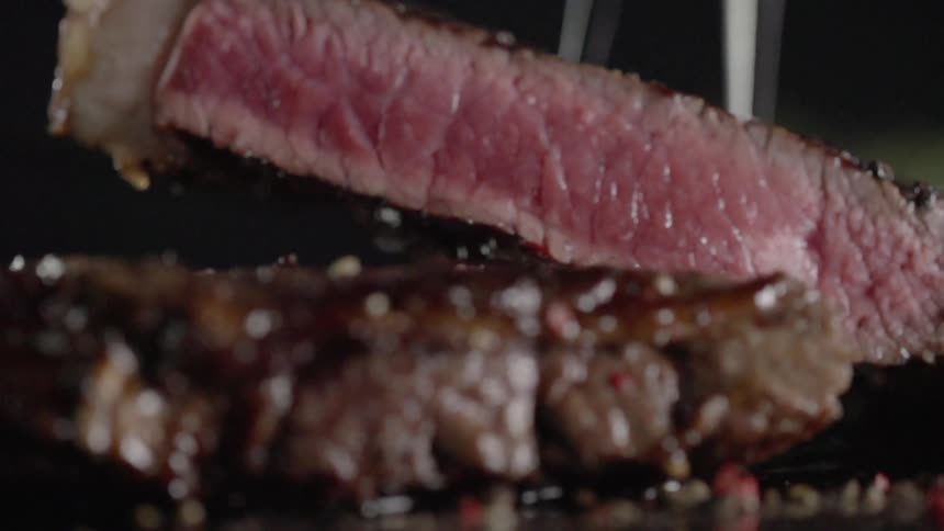Fork lifts up a piece of steak