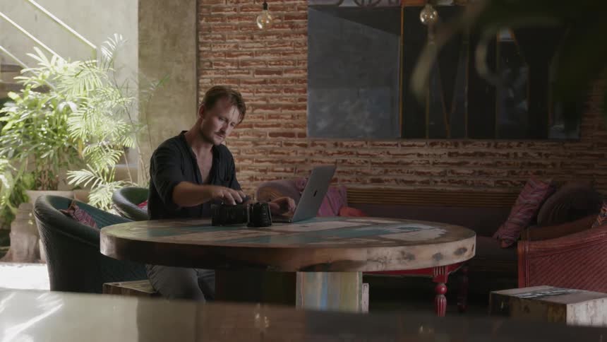 A man uses a laptop at a table