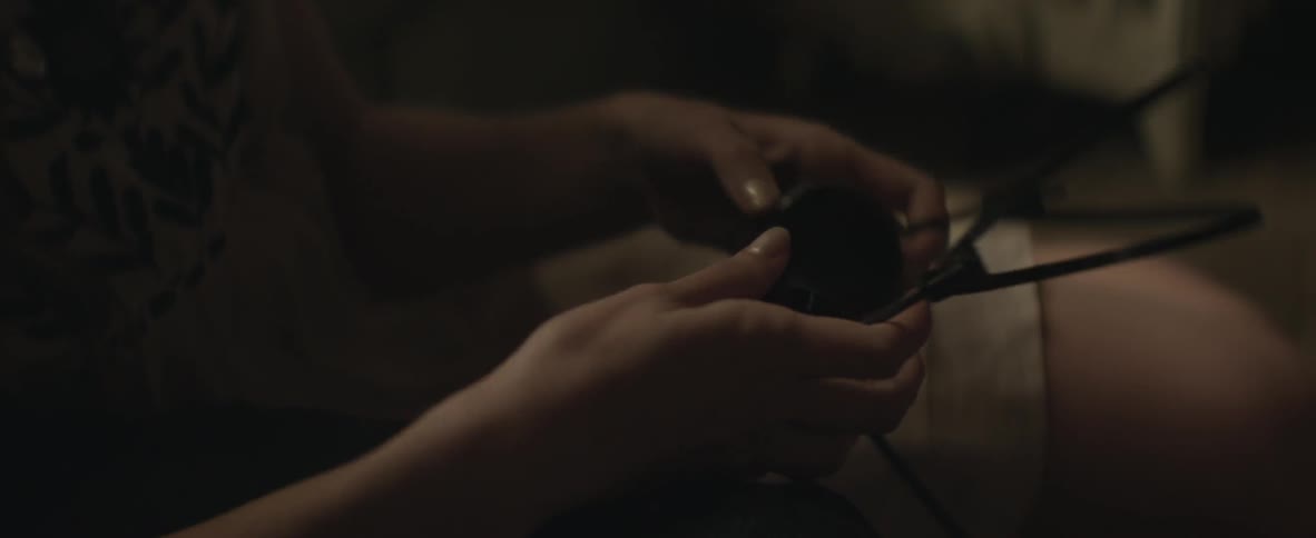 A woman holding a headset and putting it on