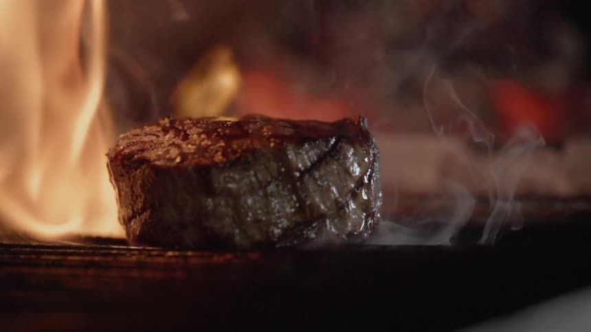 A steak is cooked on the grill