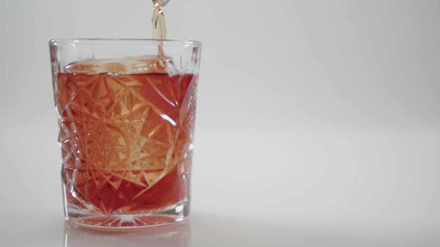 A drink is poured into a glass