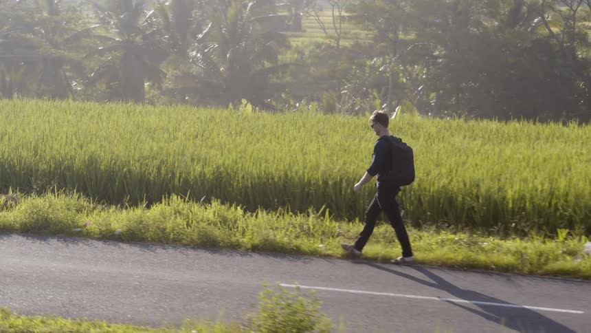 A man walks up a rural road