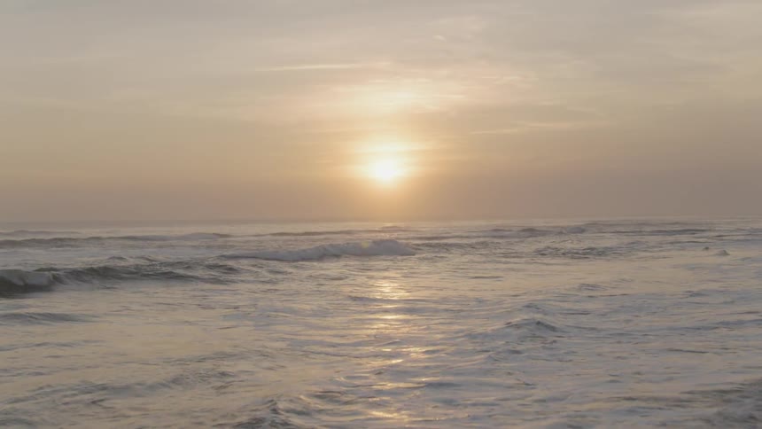 The sun shines on the flowing waters on the beach