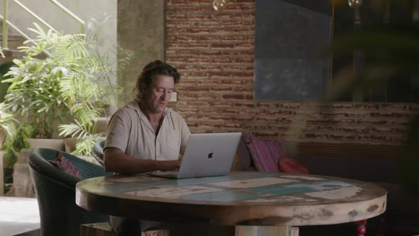 A man uses a laptop at a table