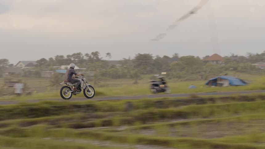 A man rides a motorcycle on a rural road