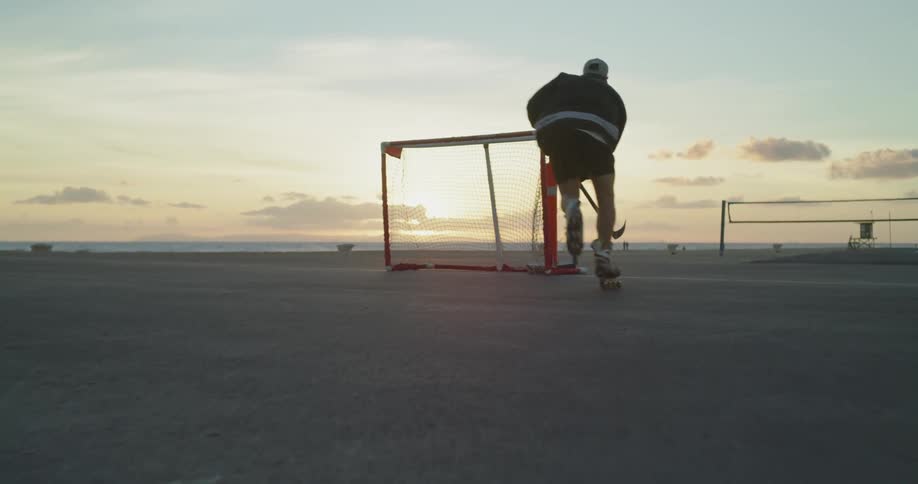 A man plays roller hockey on the beach