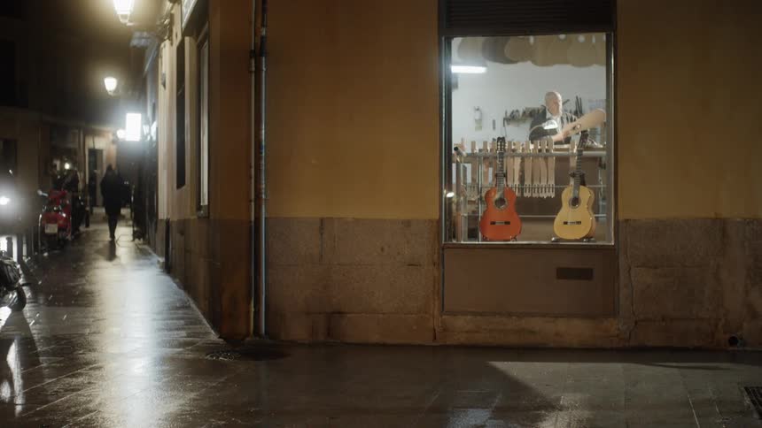 Guitars are displayed for sale at a shop window