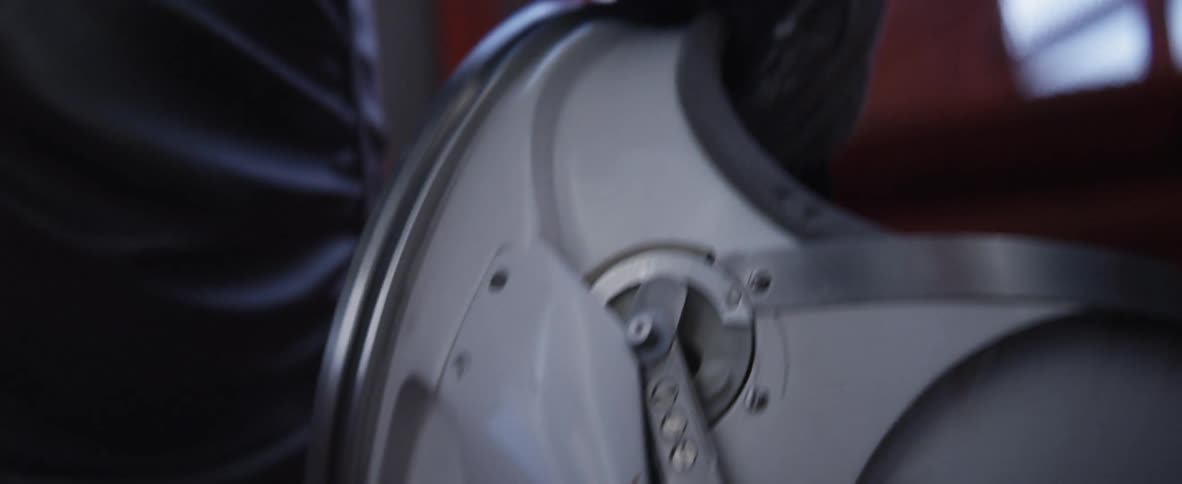 An astronaut carries his helmet up the stairs