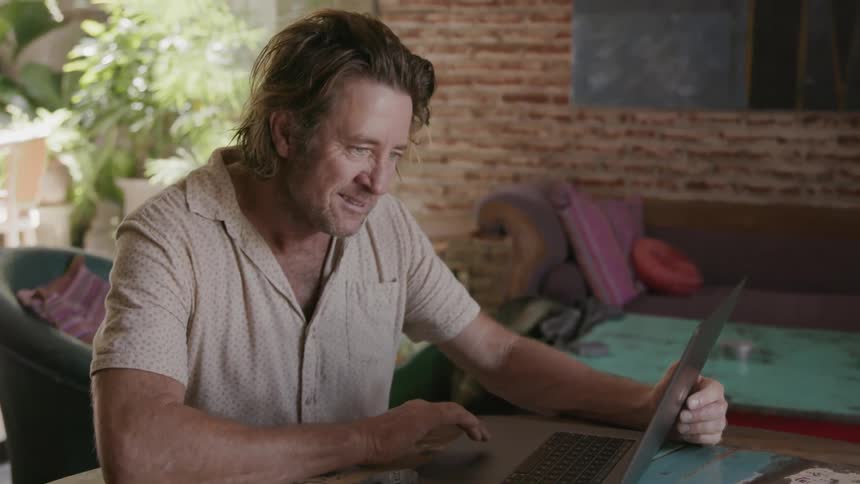 A man uses a laptop on a table