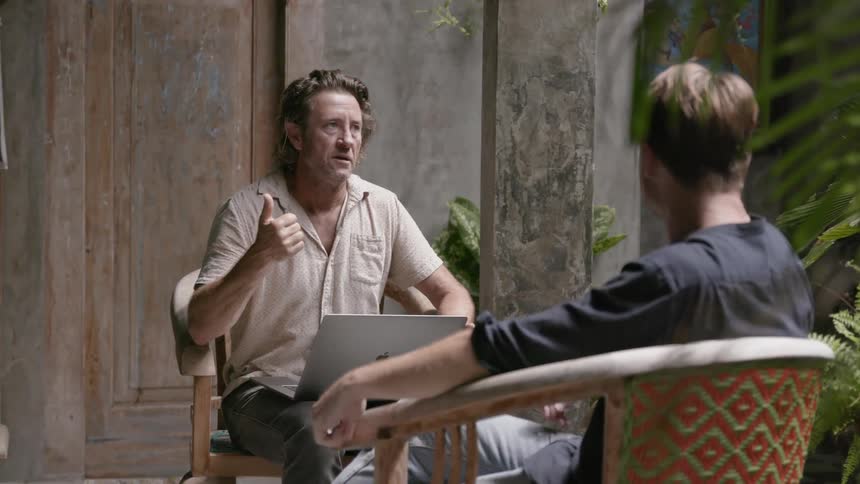 Two men sit together talking