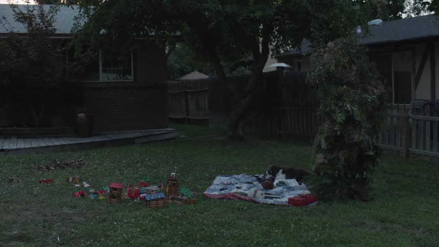 A monster walks towards a house at sunset